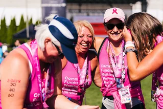 four women in pink smiling at an event
