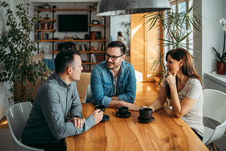 three people conversing at table