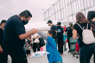 man fist bumping child in crowd